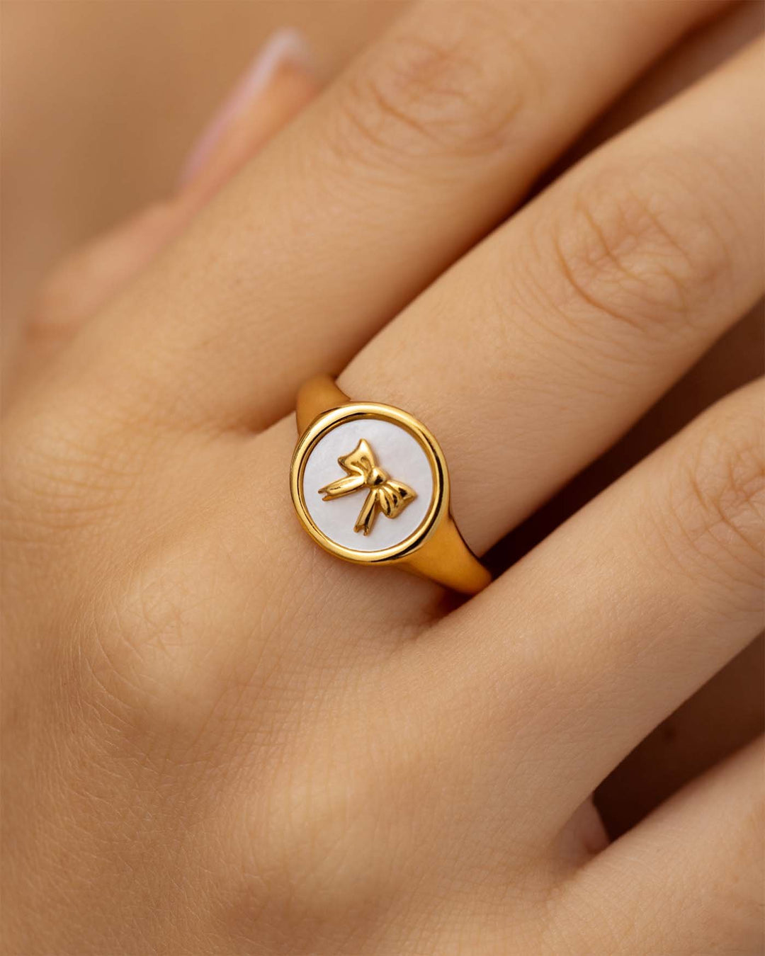 close up dell'anello fiocco placcato oro indossato