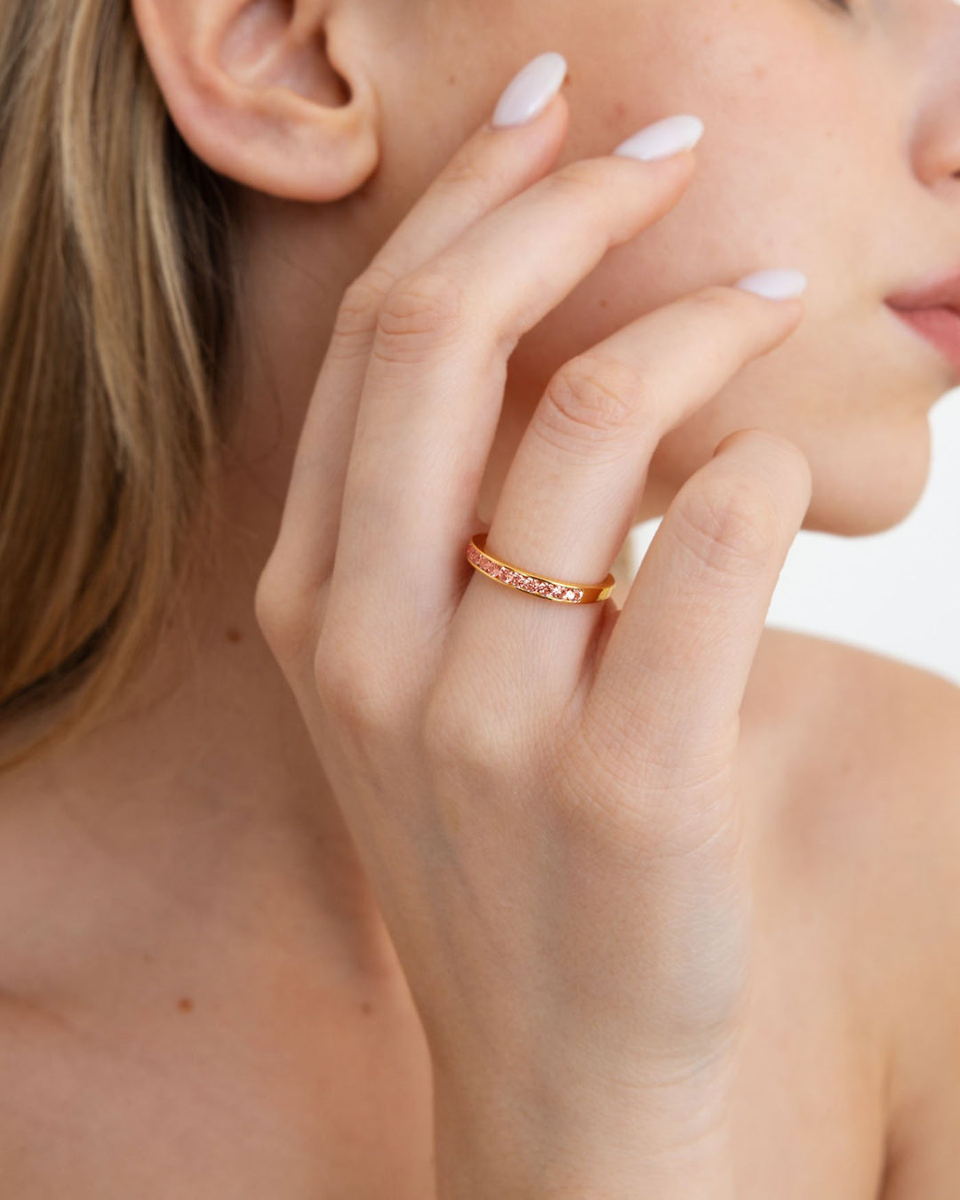 close up dell'anello zirconia rosa placcato oro indossato su modella