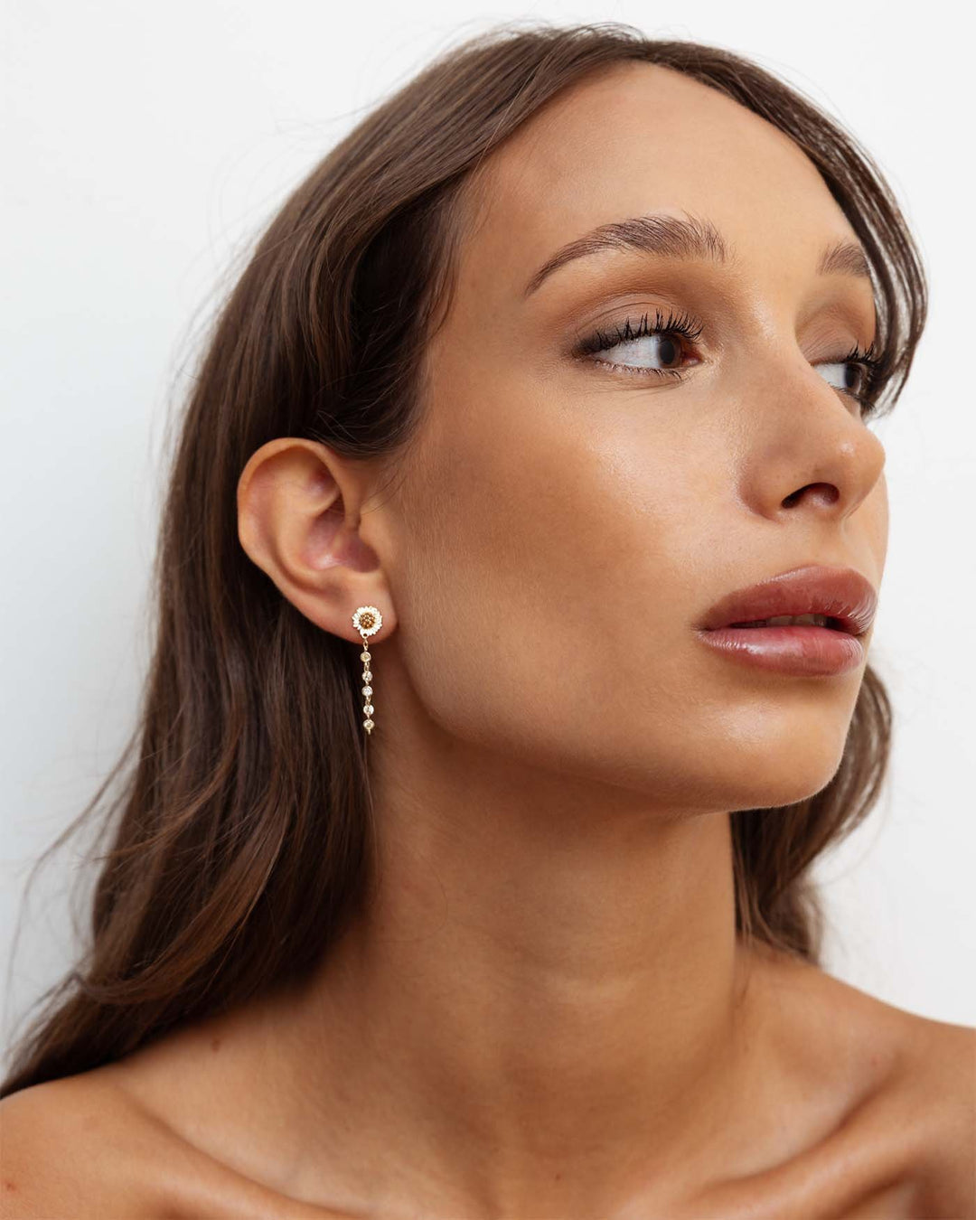 orecchino bond in argento con catenella pendente e girasole indossato su modella