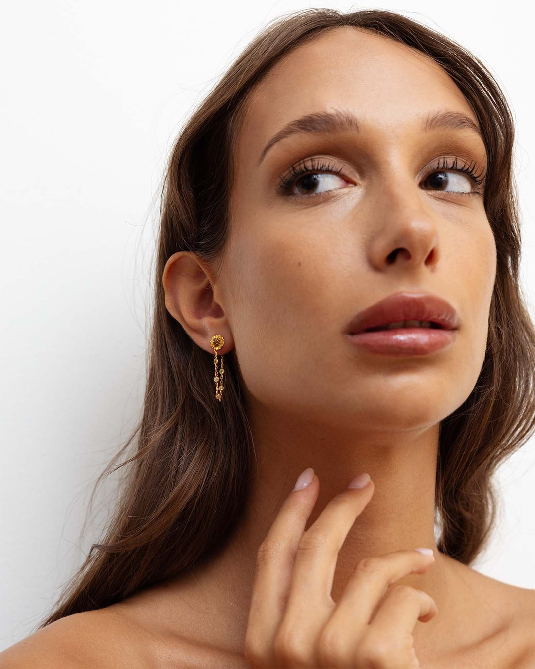orecchino bond placcato oro con catenella pendente e girasole indossato su modella