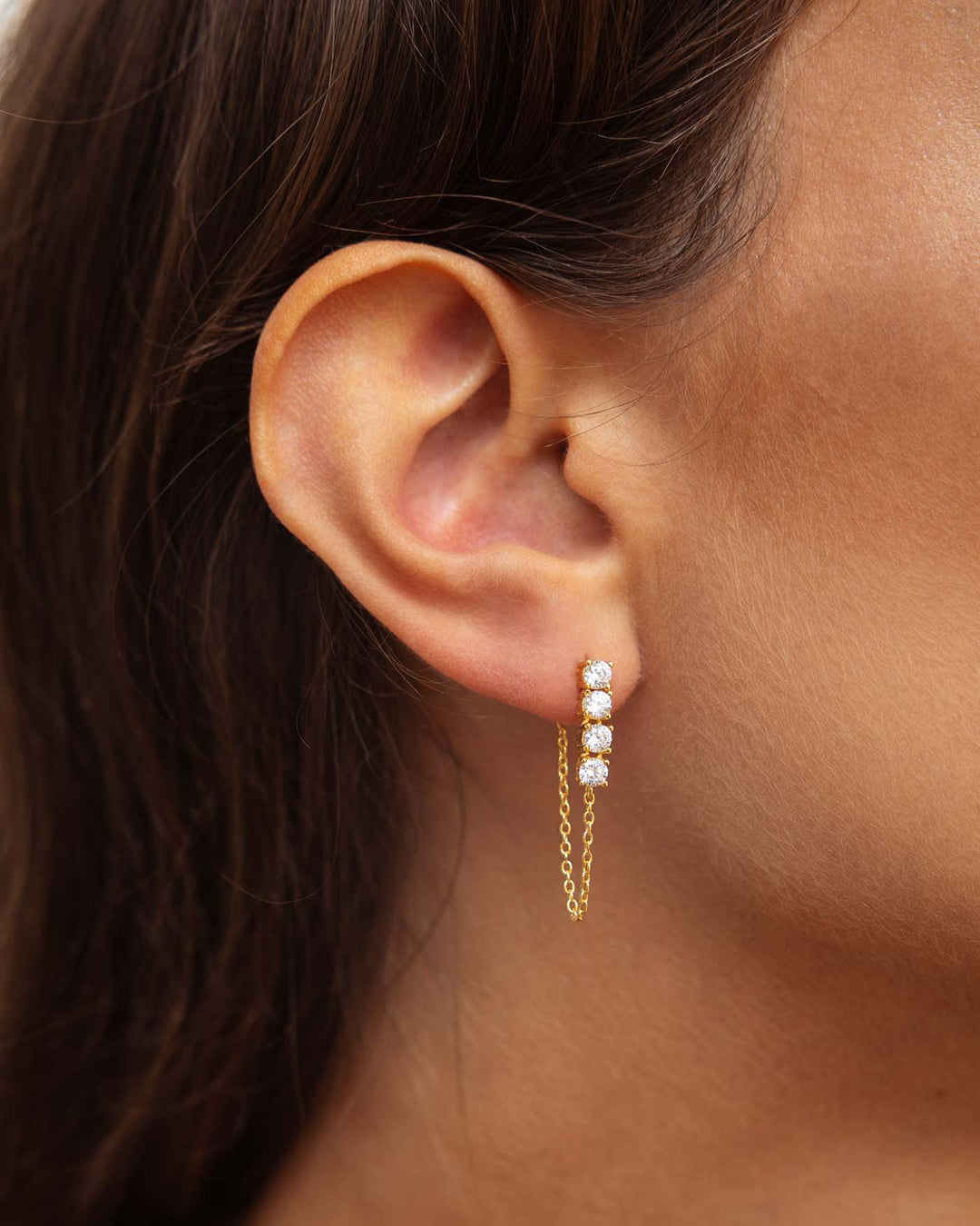 orecchino bond placcato oro con catenella pendente e quattro punti luce indossato