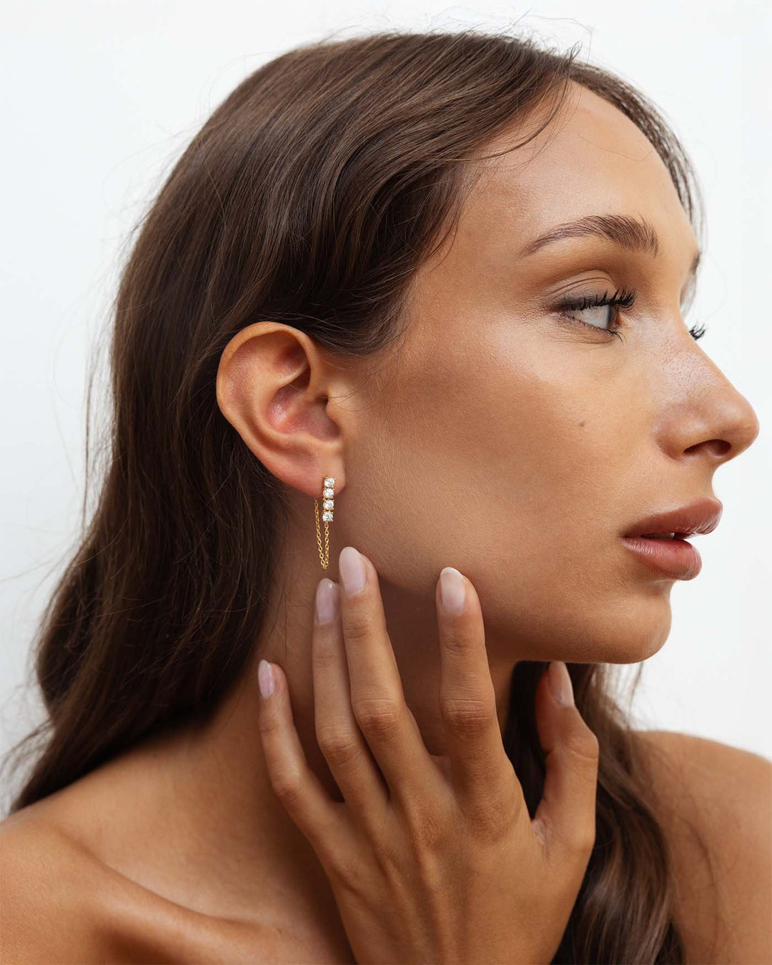 orecchino bond placcato oro con catenella pendente e quattro punti luce indossato su modella