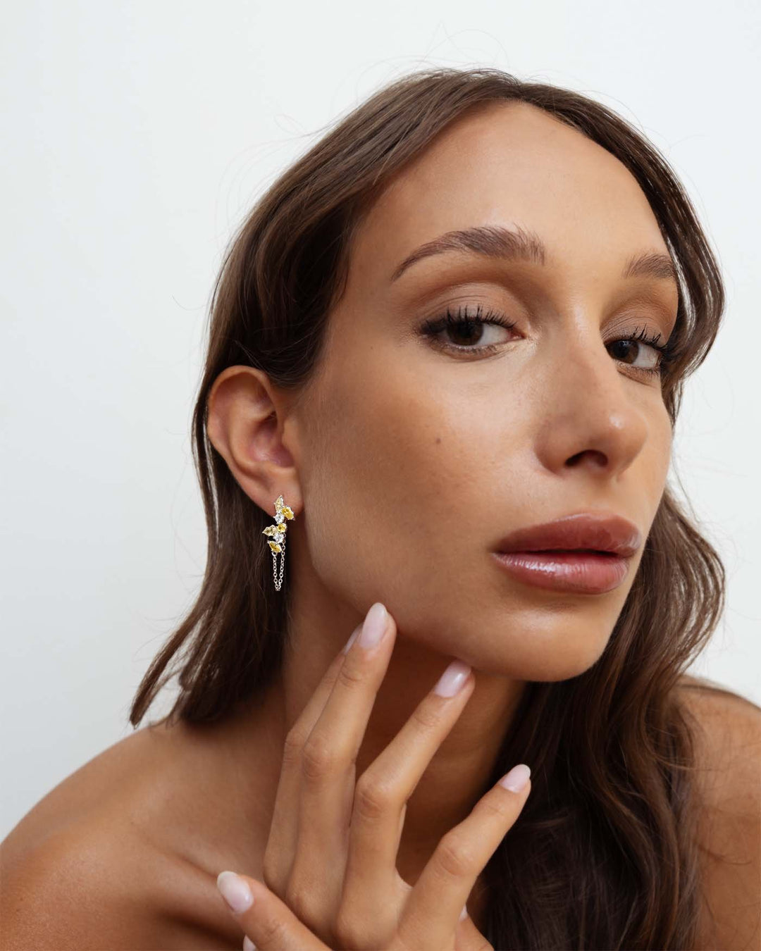 orecchino bond in argento con catenella pendente e pietre gialle indossato su modella