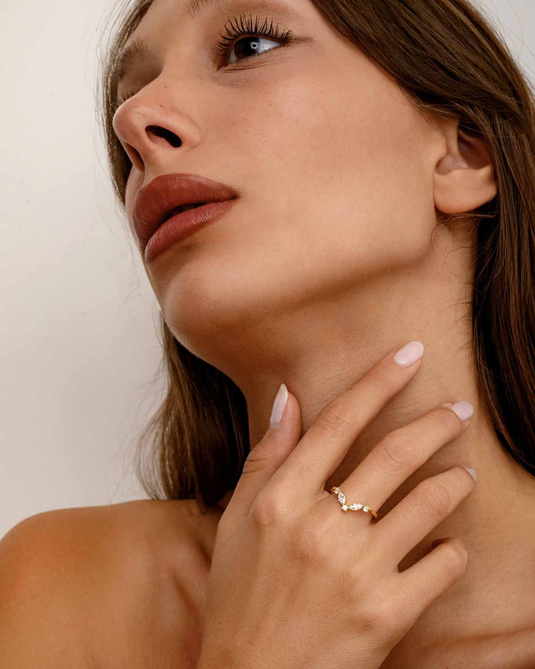modella indossa anello chevron con pietre bianche oro