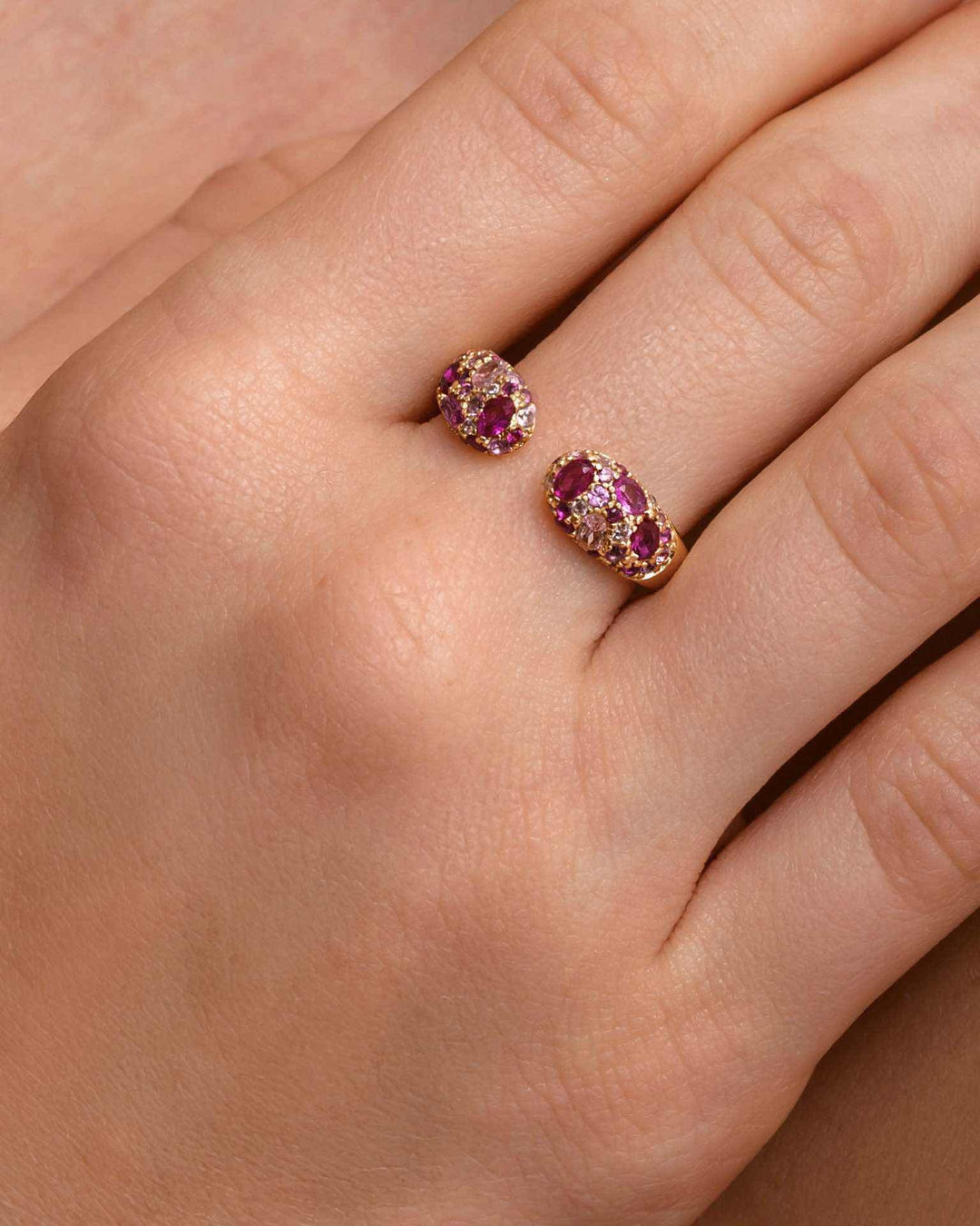 close up indossato anello aperto con punti luce rosa e fucsia oro