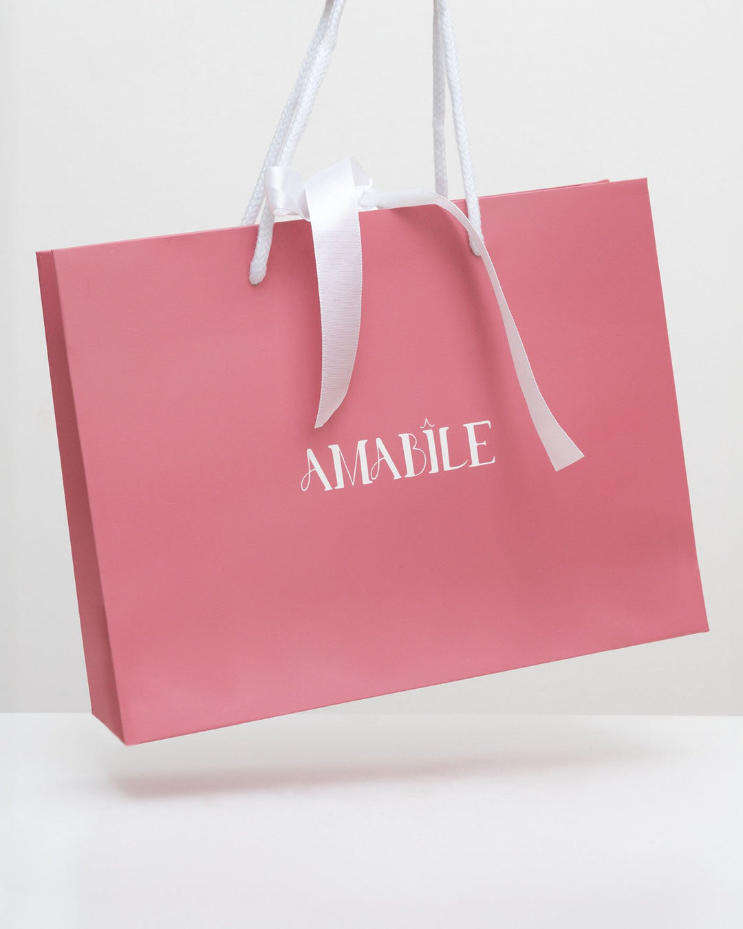 busta rigida rosa di amabile con fiocco bianco