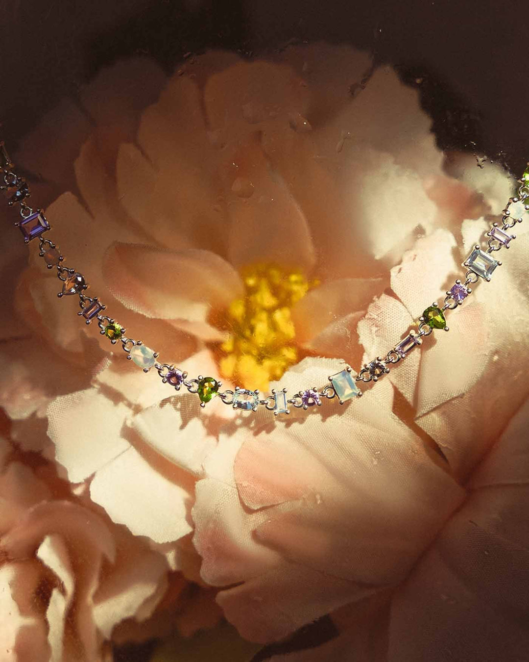 choker con pietre colorate su sfondo floreale