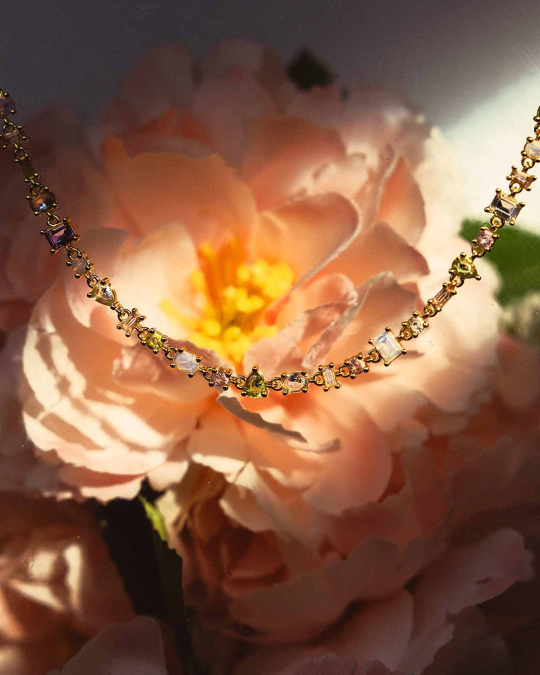 choker con pietre colorate su sfondo floreale