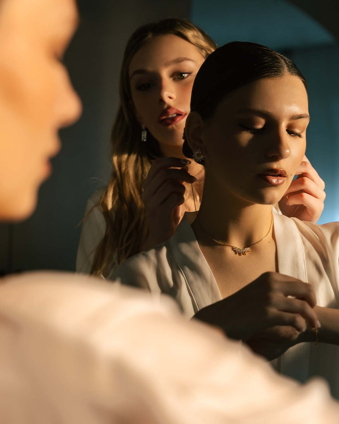 damigella chiude la collana bouquet sul collo della sposa in preparazione