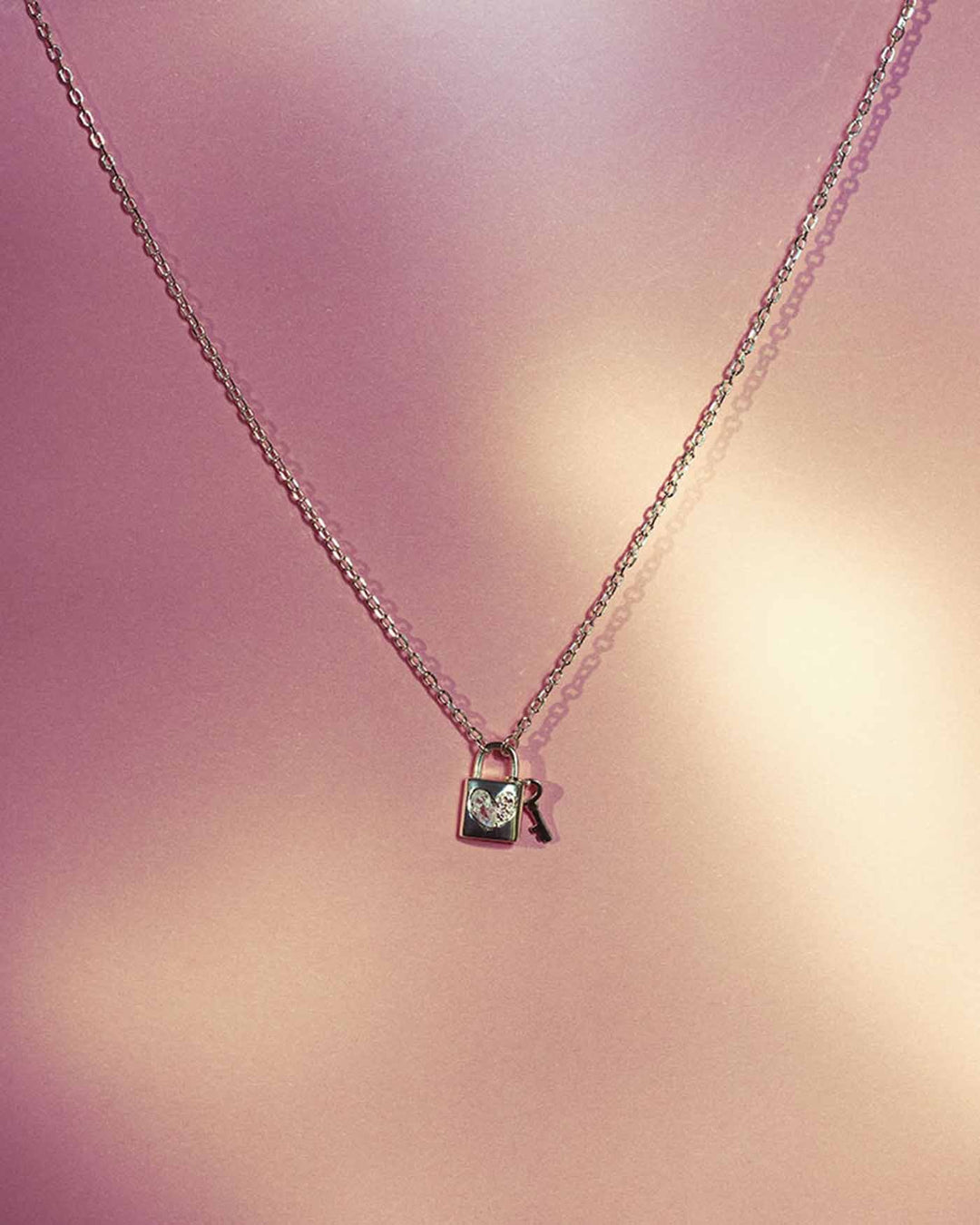 collana heartlock argento su sfondo rosa