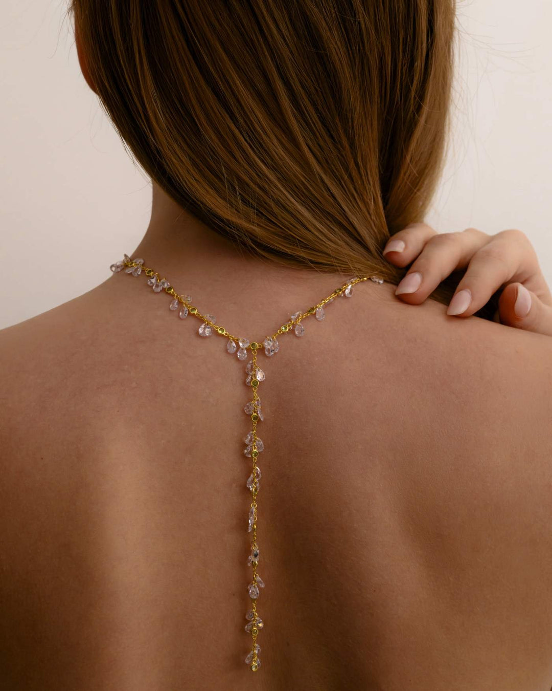 modella indossa sulla schiena collana rosé