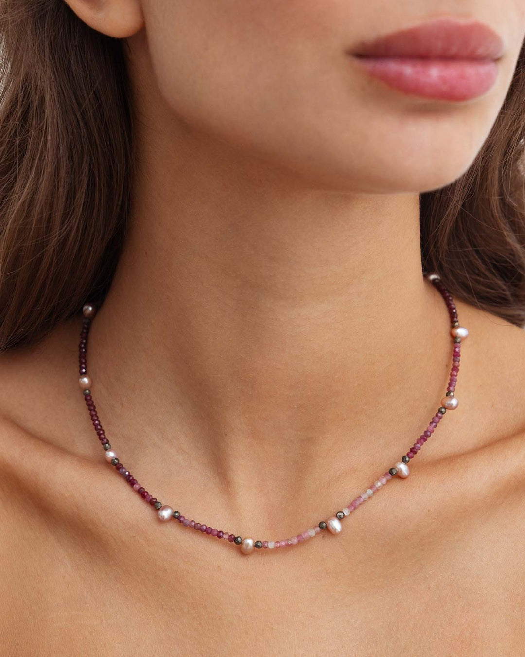 close up della collana rosewood in argento con perline rosa e bordeaux e perle di fiume indossata