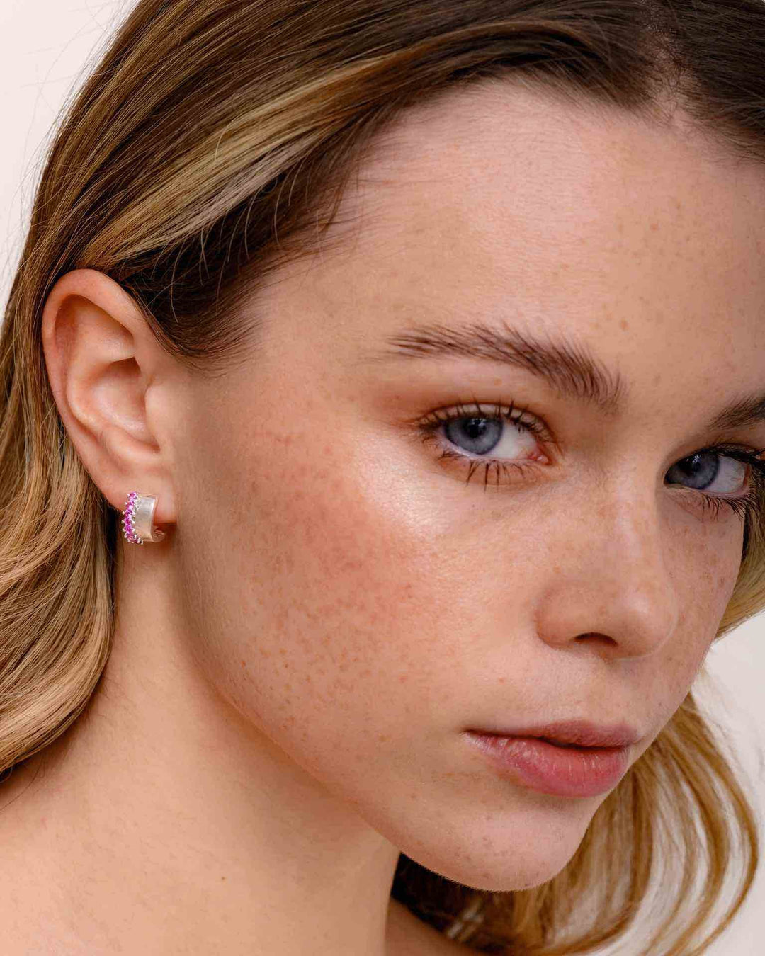 modella indossa Orecchino a Cerchio Spesso con Zirconie Fucsia argento