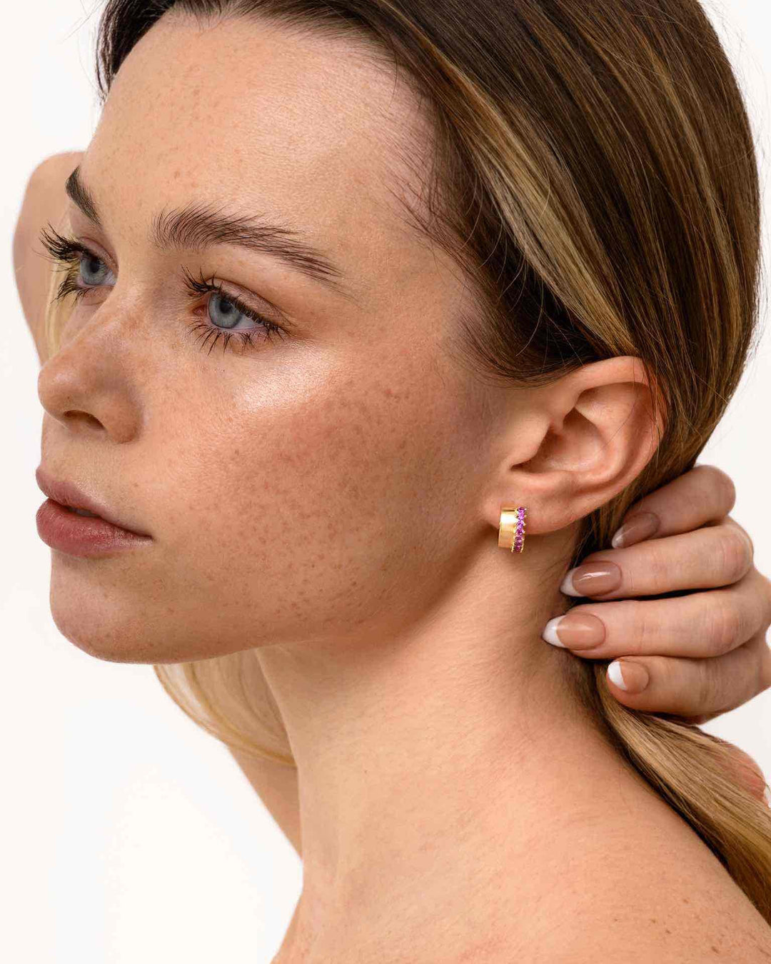 modella indossa Orecchino a Cerchio Spesso con Zirconie Fucsia oro