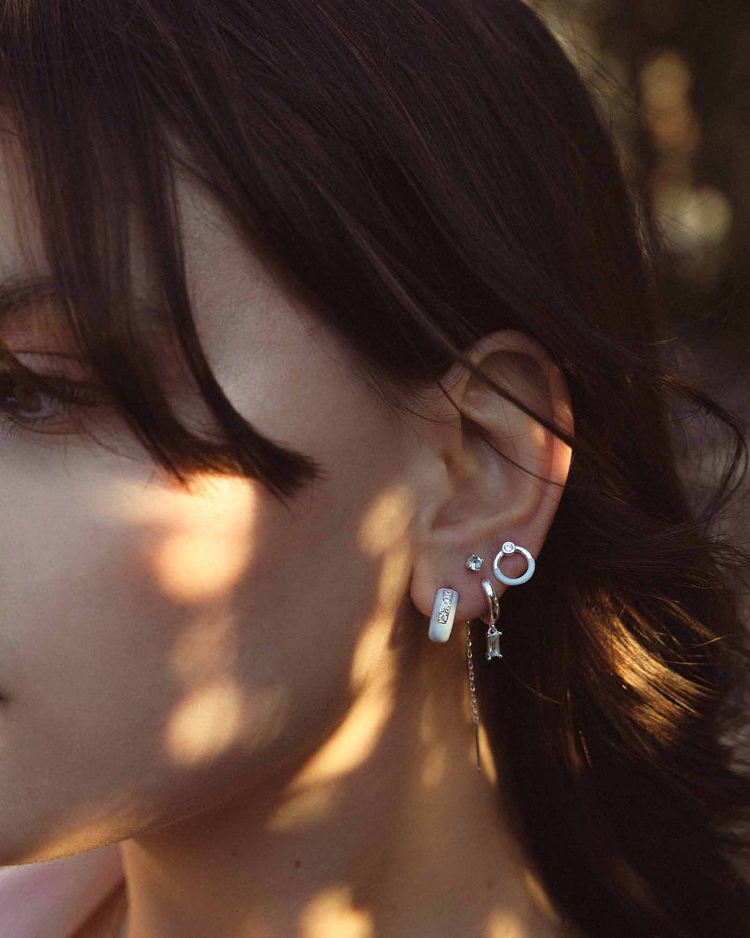 modella indossa hoop glossy abbinato con  altri orecchini 