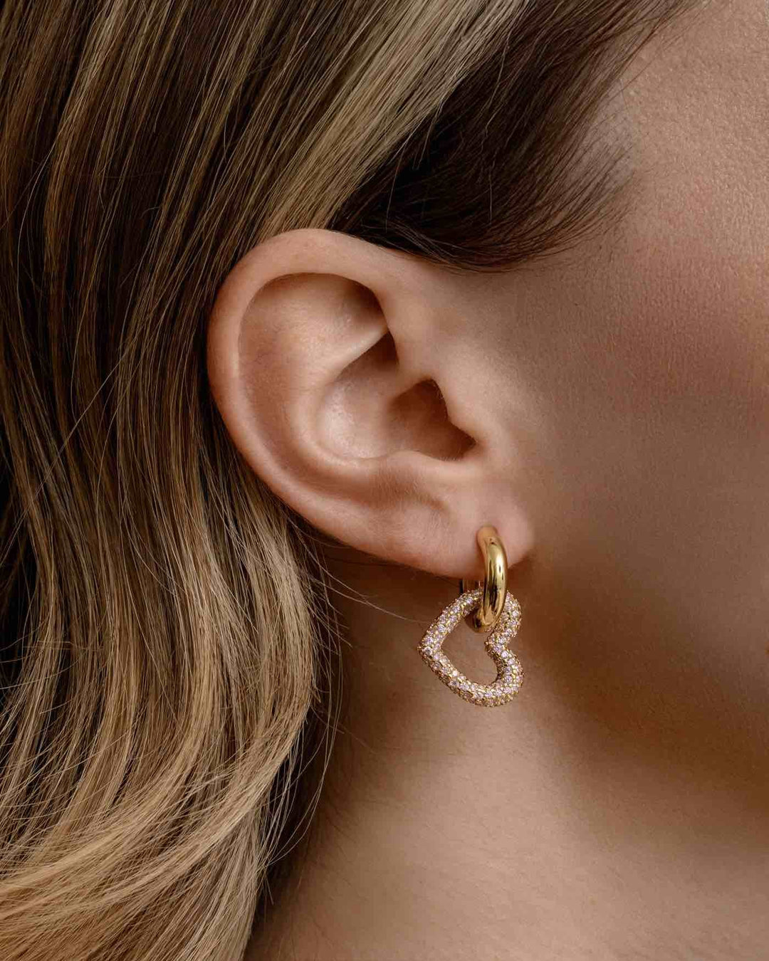 close up indossato orecchino a cerchio con pendente a cuore oro