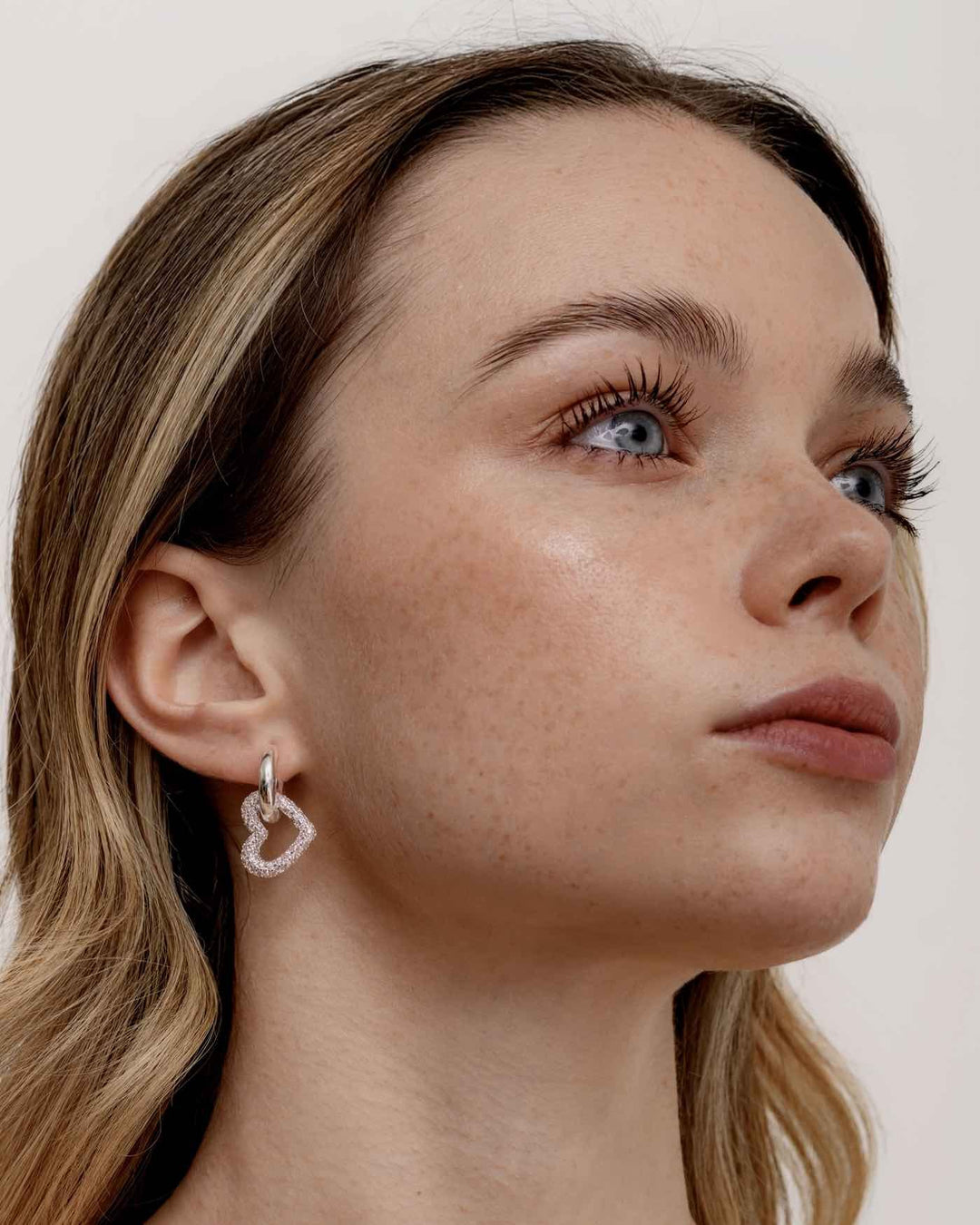 modella indossa orecchino a cerchio con pendente a cuore argento