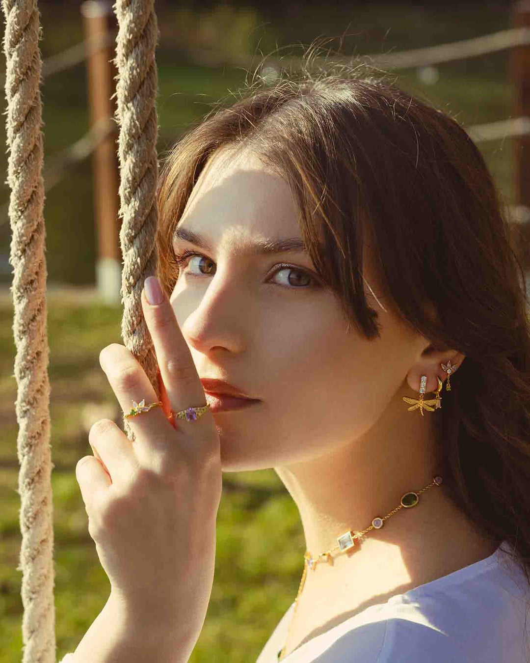 modella indossa orecchino libellula oro abbinato a altri gioielli della collezione lilypad