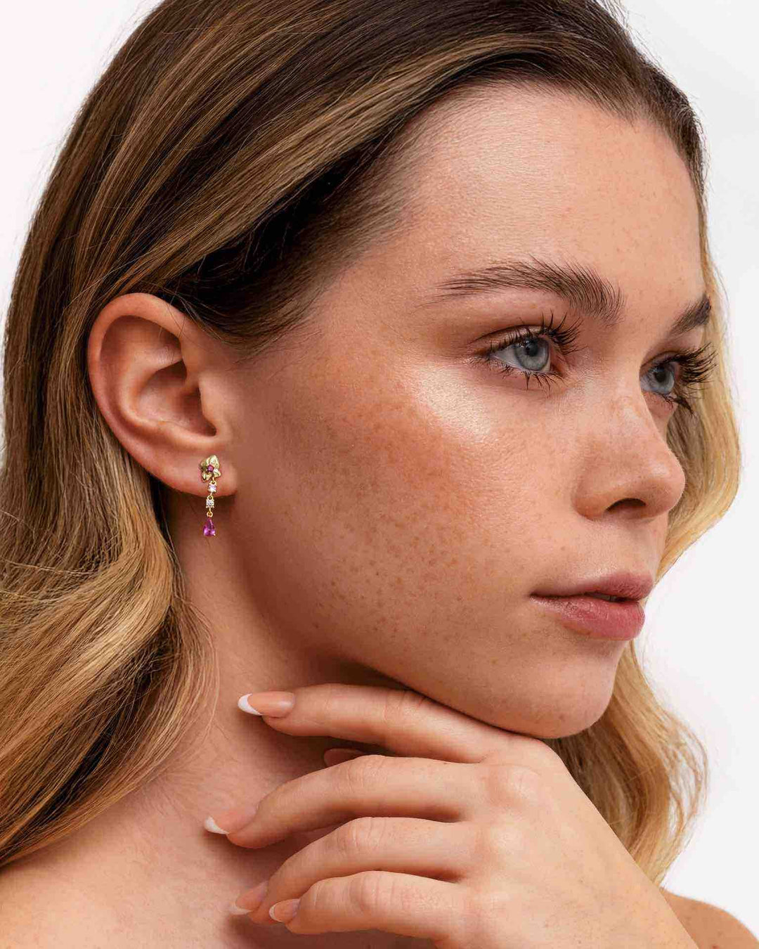 modella indossa orecchino pendente corto con bocciolo di rosa oro