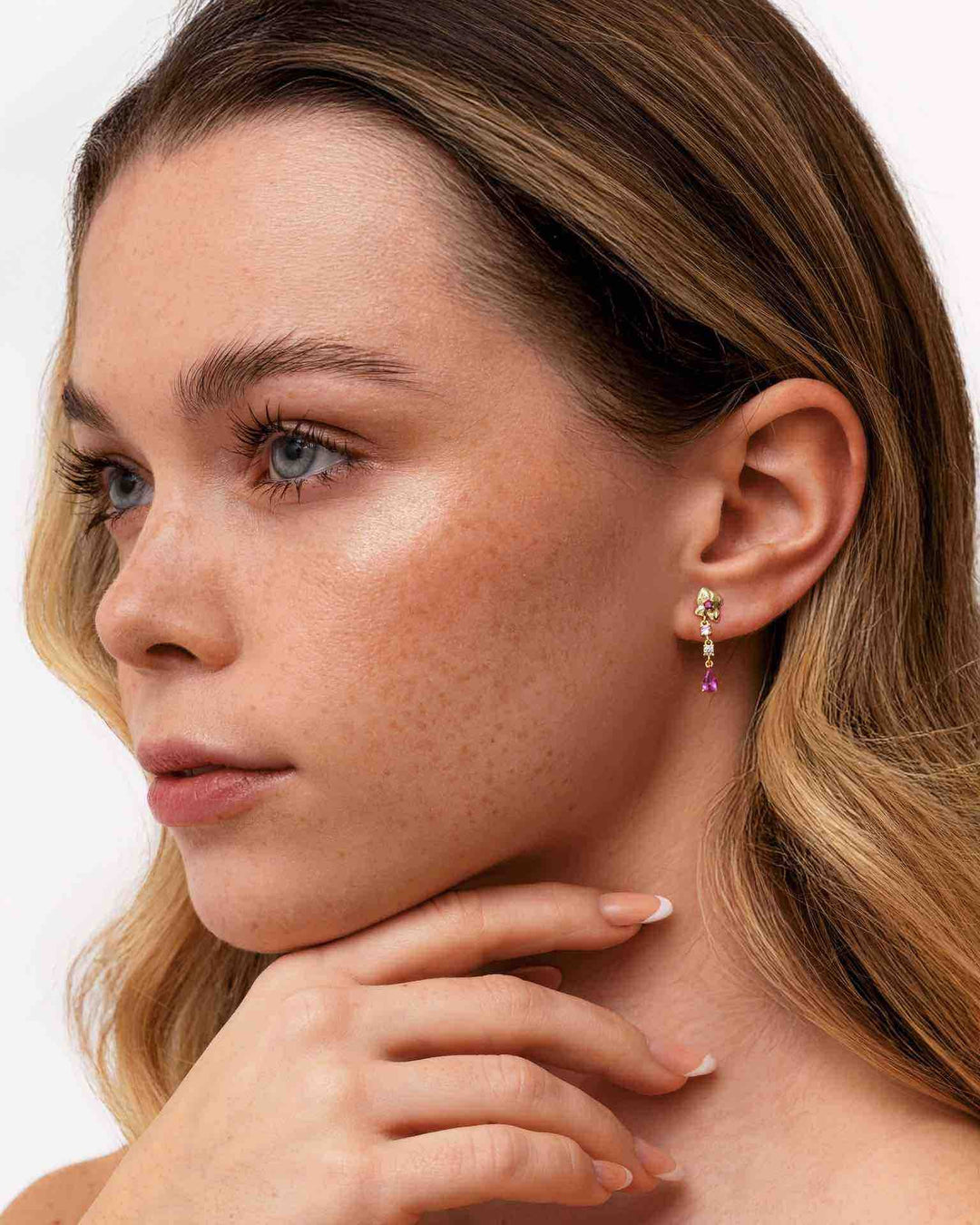 modella indossa orecchino pendente corto con bocciolo di rosa oro