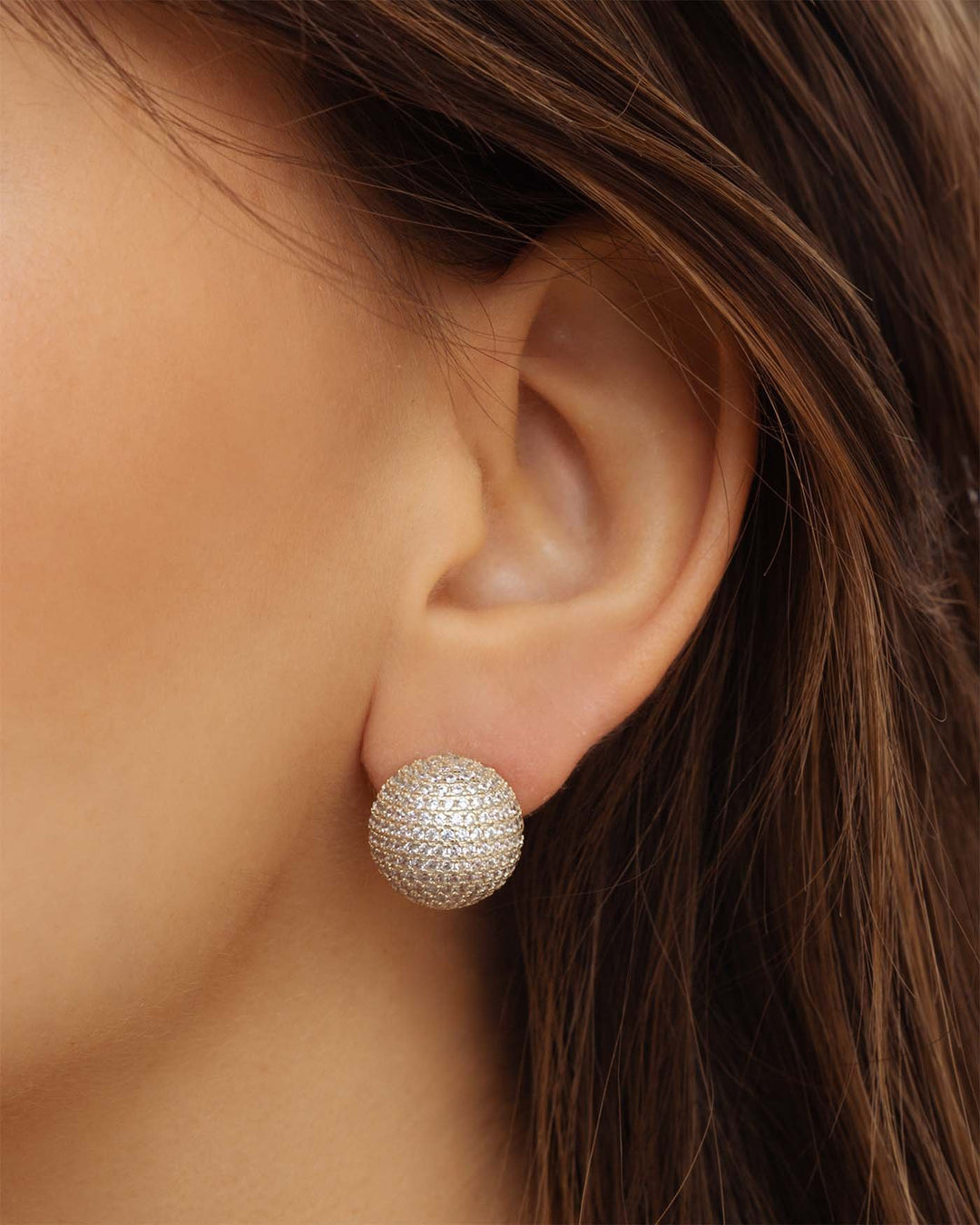 close up dell'orecchino sfera pave argento indossato