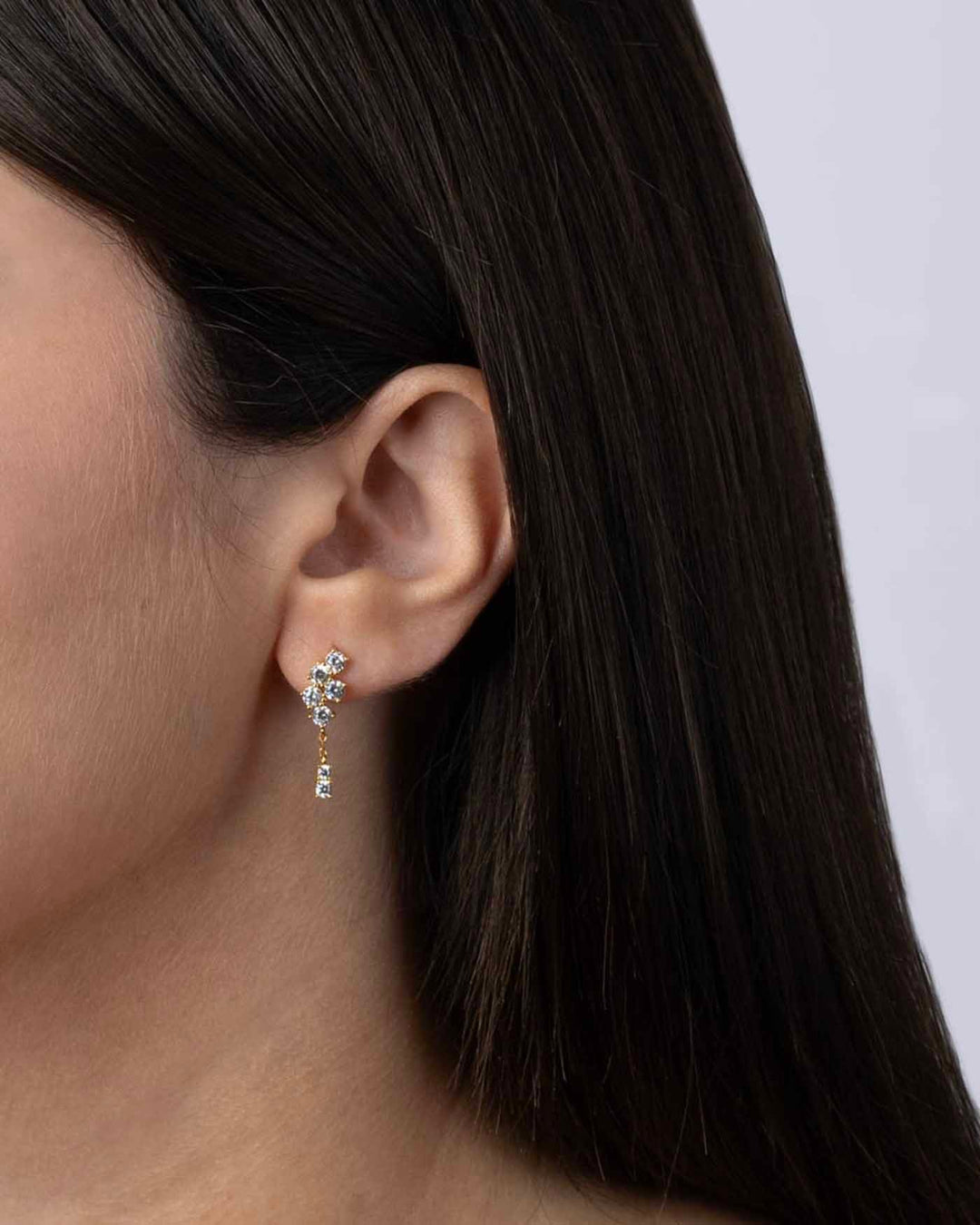 indossato orecchino pendente oro con pietre bianche vista laterale