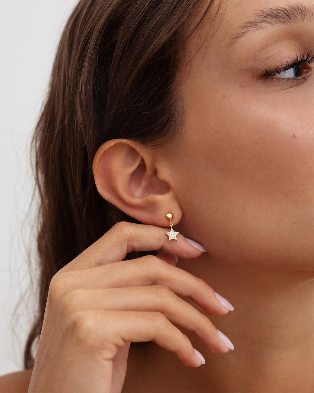 modella indossa orecchino stella pavé oro